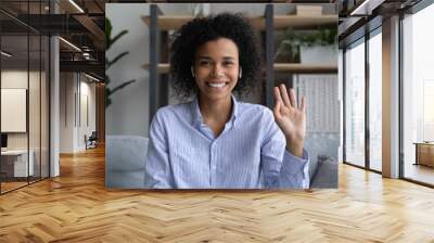 Headshot portrait of smiling young African America female look at camera wave have webcam virtual event. Happy biracial woman speak talk on video call at home. Communication, technology concept. Wall mural