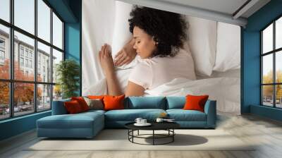 Healthy serene african girl sleeping in comfortable bed, top view Wall mural