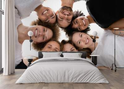 Low angle smiling diverse people standing in circle, celebrating success Wall mural