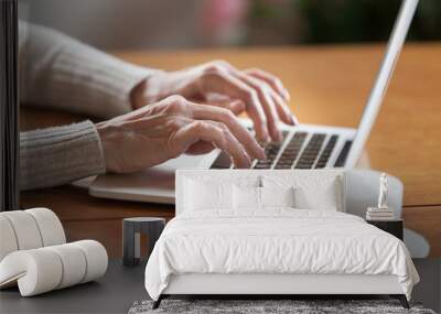 Mature female hands typing text on keyboard, senior elderly business woman working on laptop, old or middle aged lady using computer concept writing emails, communicating online, close up view Wall mural