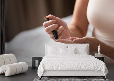 Mature woman using blood glucose meter close up Wall mural