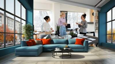 Mixed raced team of managers discussing work issues in meeting room. Diverse group of employees or interns talking during training break. Busy office colleagues having briefing by conference table Wall mural