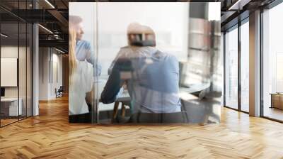 Multi ethnic business people negotiating at table view through glass Wall mural