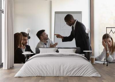 Multi-ethnic businessmen having conflict accusing each other during meeting Wall mural