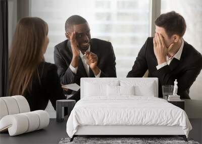 Multiracial businessmen hiding face with hands, sneaking look at each other while businesswoman presenting document, recruiters covertly discussing candidate, secretly whispering during interview Wall mural