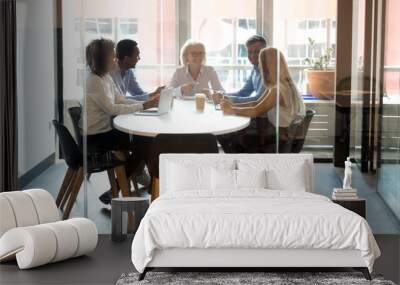 Multiracial company staff laughing talking at group meeting in office Wall mural