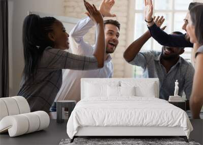 Multiracial euphoric business team people give high five in office Wall mural