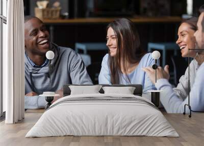 Multiracial friends girls and guys having fun laughing drinking coffee Wall mural