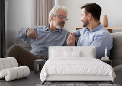 Old father talking with son, having pleasant conversation at home Wall mural