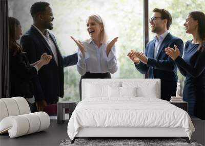 Overjoyed diverse businesspeople applaud celebrate company business success at meeting together, happy multiracial employees clap hands congratulate middle-aged businesswoman, reward concept Wall mural