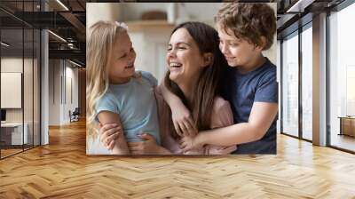 Overjoyed young mother play with excited little preschooler children enjoy family weekend at home, happy mom have fun engaged in funny game activity with small kids, relax rest together Wall mural