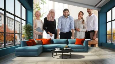 Portrait of confident male team leader with smiling diverse colleagues. Wall mural