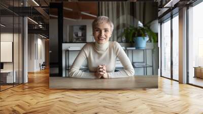 Portrait of happy attractive young businesswoman with short haircut sitting at table, looking at camera. Web cam view skilled female worker holding video call meeting with partners or client from Wall mural