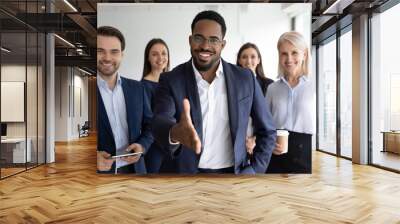 Portrait of smiling African American team leader stretch hand greeting job candidate or applicant in office. Happy multiracial businesspeople meet welcome newcomer at workplace. Employment concept. Wall mural