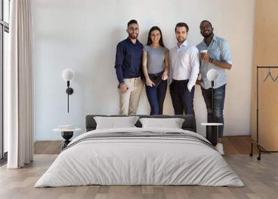 Portrait of smiling diverse employees posing together Wall mural