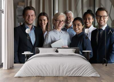 Portrait of smiling diverse employees workers with mature team leader executive standing in office, looking at camera, happy business partners colleagues coworkers posing for corporate photo Wall mural