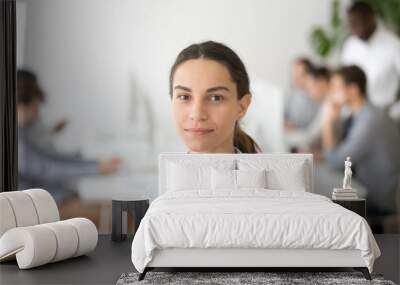 Portrait of smiling female employee looking at camera, posing in coworking shared workspace, attractive woman posing for company business catalogue, having photoshoot in modern office. Human resources Wall mural