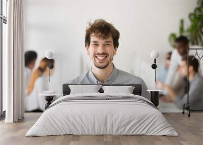 Portrait of smiling male Caucasian employee laughing looking at camera, posing in coworking shared space, shooting for company business catalogue. Concept of laughter, leadership, outsourcing Wall mural