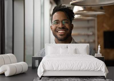 Profile picture of smiling young African American man in glasses pose in own home apartment. Close up headshot portrait of happy millennial biracial male renter or tenant in spectacles show optimism. Wall mural