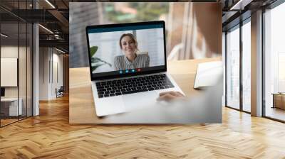 Rear over shoulder view of man talk speak with smiling female colleagues on video online call on laptop. Diverse businesspeople have webcam digital virtual zoom meeting. Communication concept. Wall mural