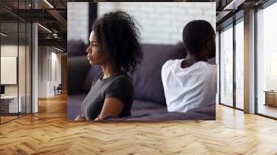 Sad unhappy african wife avoiding talk ignoring husband after couple fight feels indifferent offended, upset frustrated black girlfriend tired of problems, thinking of divorce with selfish boyfriend Wall mural