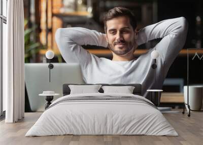 Serene businessman sitting at table feels satisfied accomplishing work Wall mural