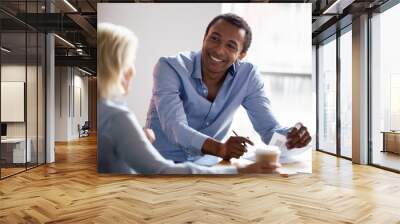 Smiling african american manager talking with client at business meeting Wall mural