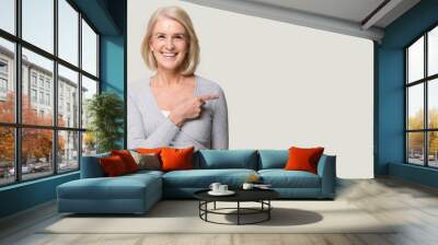 Smiling aged woman point at blank copy space Wall mural