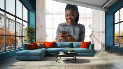 Smiling biracial female employee using modern cellphone Wall mural