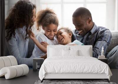 Smiling black family have fun at home with little kids Wall mural