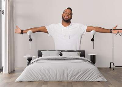 Smiling black man stretch hands show big sales Wall mural