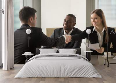 Smiling businesswoman handshaking with partner at beginning of multinational negotiations. Afro american entrepreneur with female secretary introducing themselves on meeting with caucasian colleague Wall mural