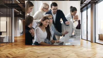 Smiling diverse business people working in small groups on project in modern office. Motivated different ages teammates developing international company growth strategy, sitting at shared table. Wall mural