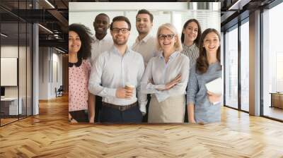 Smiling diverse employees posing for photo in office Wall mural