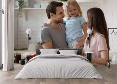 Smiling father holding little daughter, family preparing dinner in kitchen Wall mural