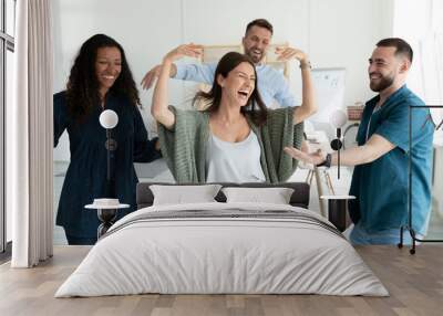 Smiling young businesswomen and businessmen dancing after successful deal. Diverse happy employee energy moving for break and relaxing. Motivated carefree multiracial business team. Wall mural