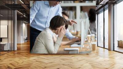 Stressed female employee suffering from discrimination of angry male boss Wall mural