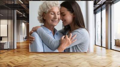 Supportive mature mother hug cuddle grown-up daughter show love and care, happy smiling elderly mom and adult girl child embrace share close intimate moment together, bonding concept Wall mural