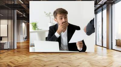 Surprised confused caucasian employee receiving dismissal notice, letter or document with unexpected news from african boss, worried shocked office worker getting fired in written message at work Wall mural