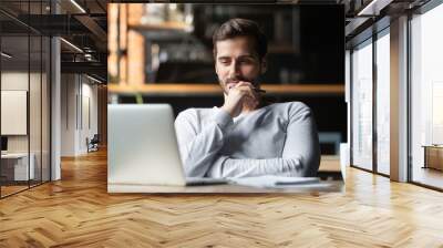 Thoughtful businessman think of online project looking at laptop Wall mural