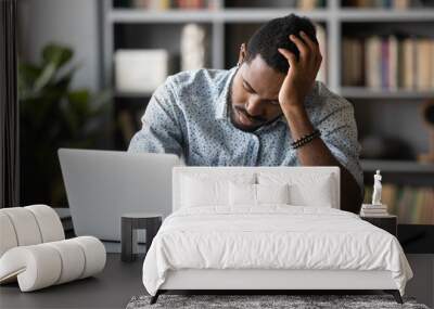 Tired bored african employee falling asleep sitting at work desk Wall mural