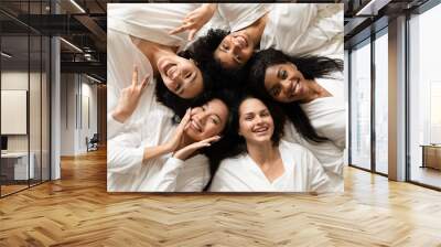 Top view five diverse women in white bathrobes lying in bed smile look at camera feels happy after body treatment, day spa procedures, resort beauty salon satisfied clients, bachelorette party concept Wall mural