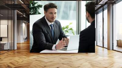 Two businessmen meet in office room sitting at table talking solving issues working on project, client and bank manager negotiating about loan lending possibility, job interview hiring process concept Wall mural