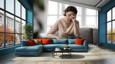 Unhappy old Caucasian woman sit on sofa at home feel lonely distressed lack communication or family support. Upset sad middle-aged female think ponder of health problems. Maturity concept. Wall mural