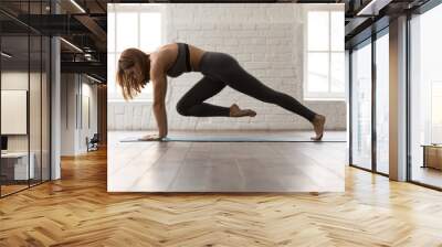 Woman practicing yoga, doing Knee to Forehead exercise, Plank pose Wall mural