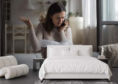 woman sit on sofa open parcel box looks inside check purchased damaged items feels angry, complainin Wall mural