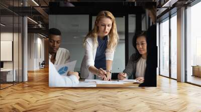 Young businesswoman explaining research results in graphs to colleagues. Wall mural