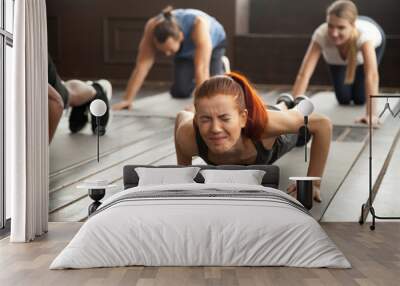 young fit sporty woman with painful face expression doing hard difficult plank fitness exercise or p Wall mural