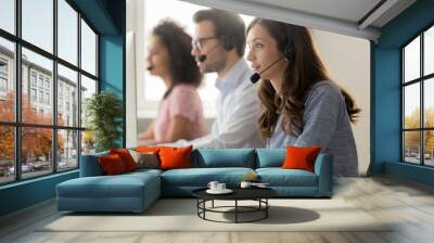 Young woman call center agent in headset consulting online client Wall mural