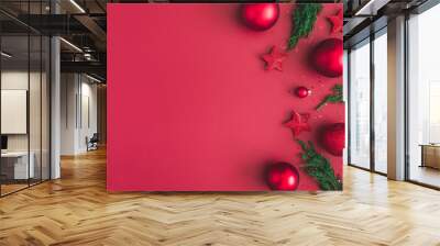 christmas composition. christmas red decorations, fir tree branches on red background. flat lay, top Wall mural